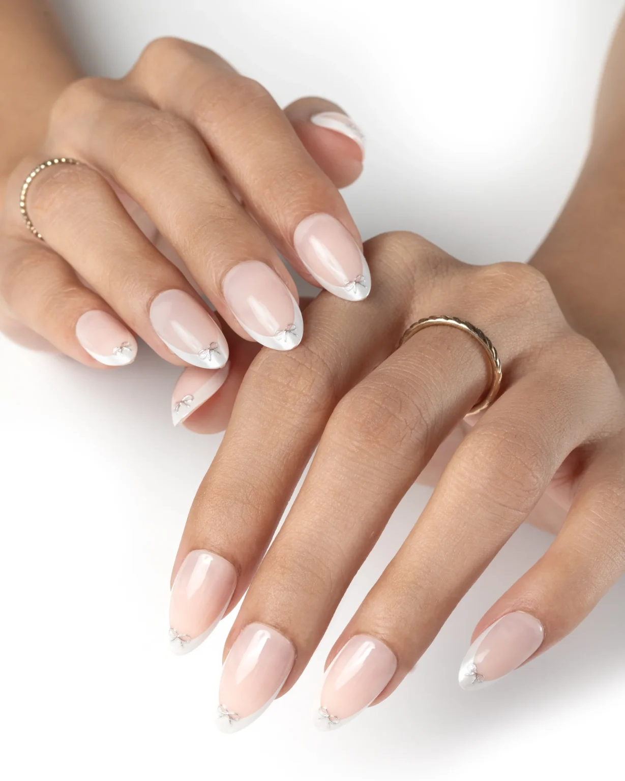 Soft nude press on nails with white French tips and minimal crystal detailing